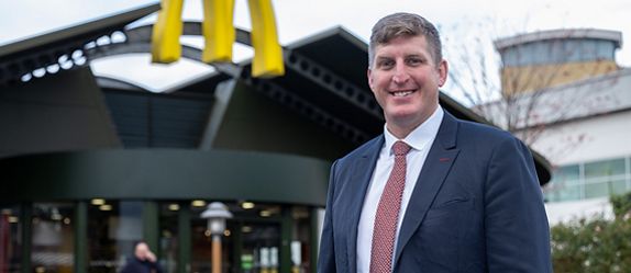 McDonald’s Restaurant Owner outside a restaurant beneath the Golden Arches.