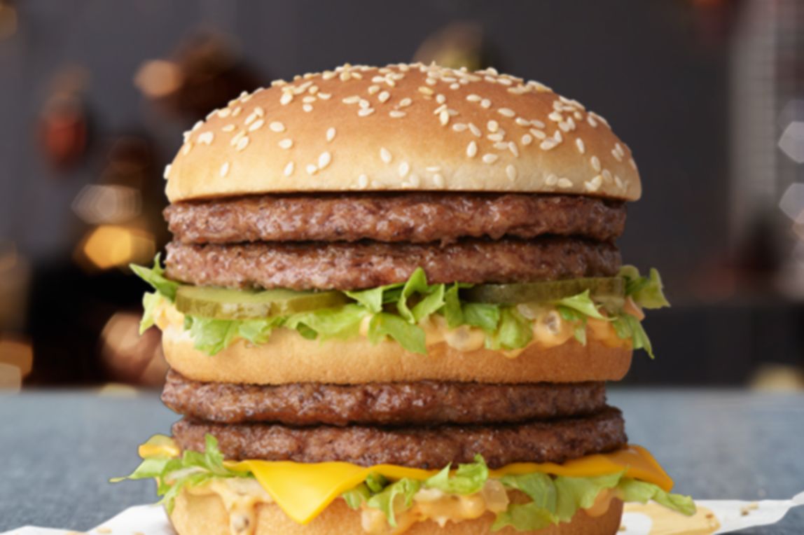 A stacked beef burger with lettuce, cheese, pickles and Big Mac sauce on a McDonald’s napkin.