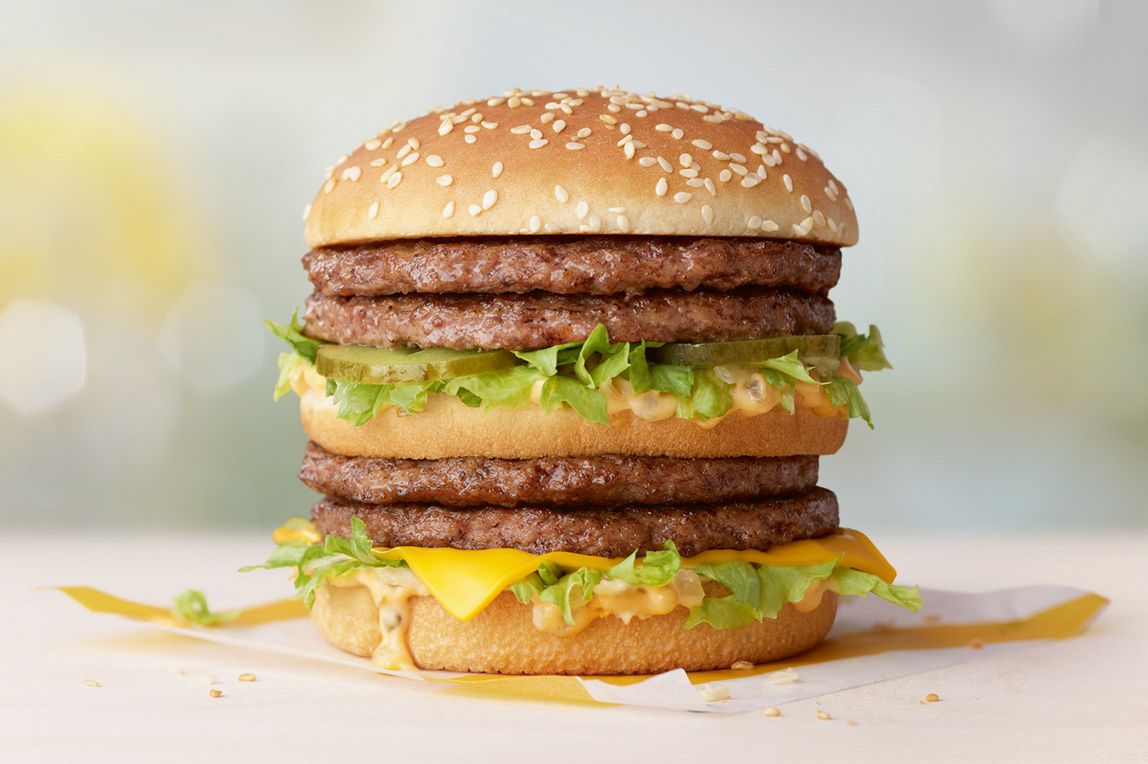 Double Big Mac burger on a wooden table.