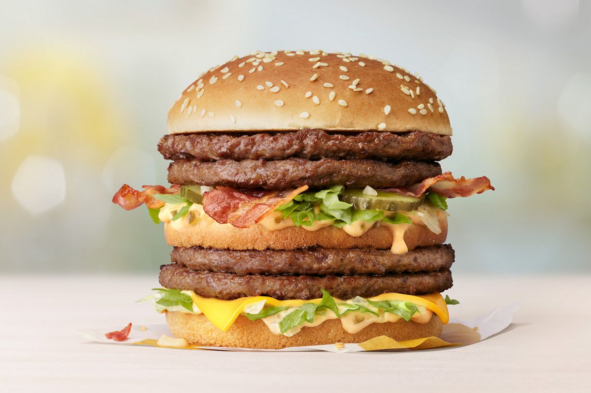 Double Big Mac with Bacon burger on a wooden table.