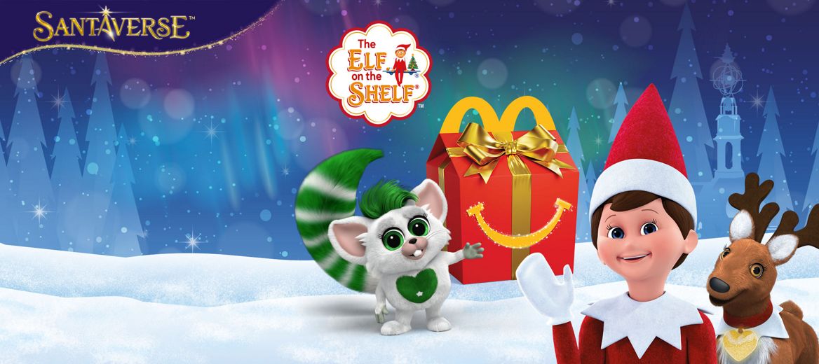 Festive winter scene with an Elf on the Shelf, a reindeer, a green-tailed bogie, and a McDonald’s Happy Meal box in snow.