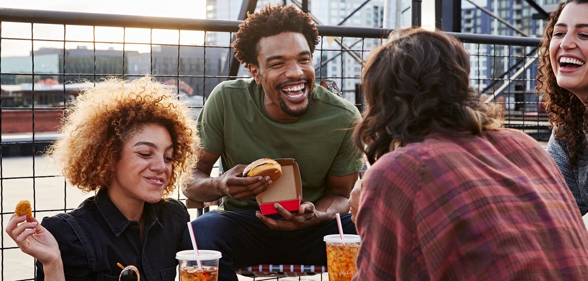 Customers laughing, eating McDonald's outside