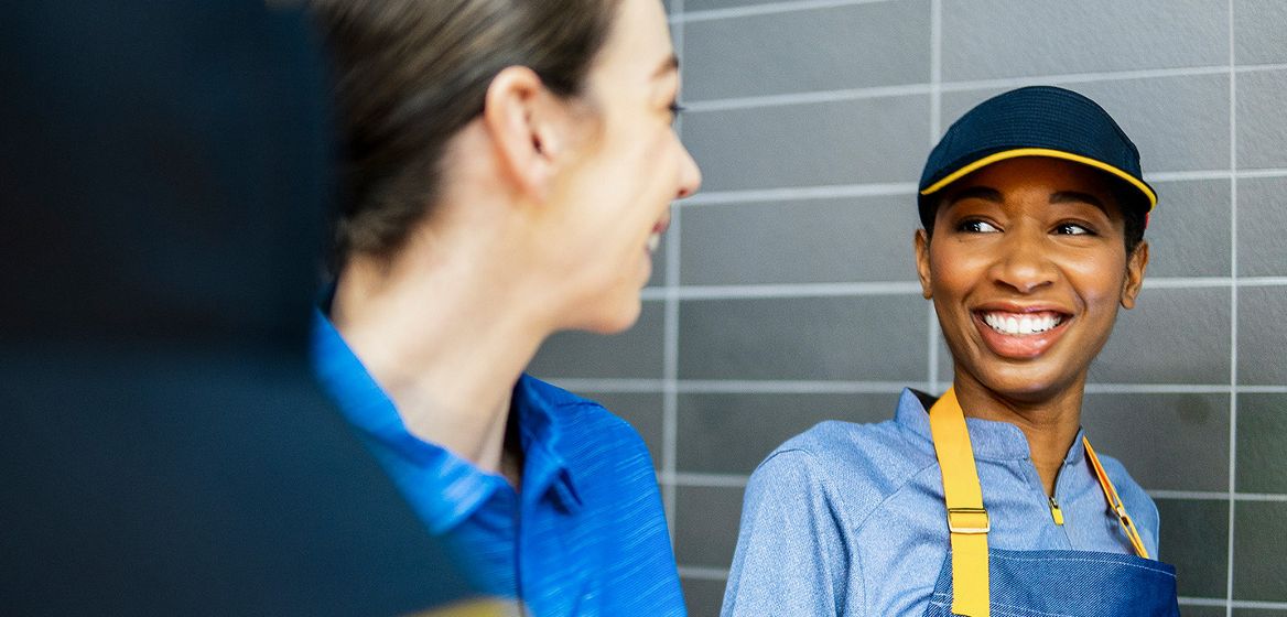 Two McDonald's employees smiling at each other