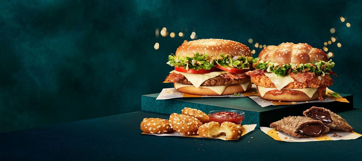 Big Tasty (with bacon,) Cheesy McCrispy, Cheese Melt Dippers and Terry's Chocolate Orange Pie on a festive green background