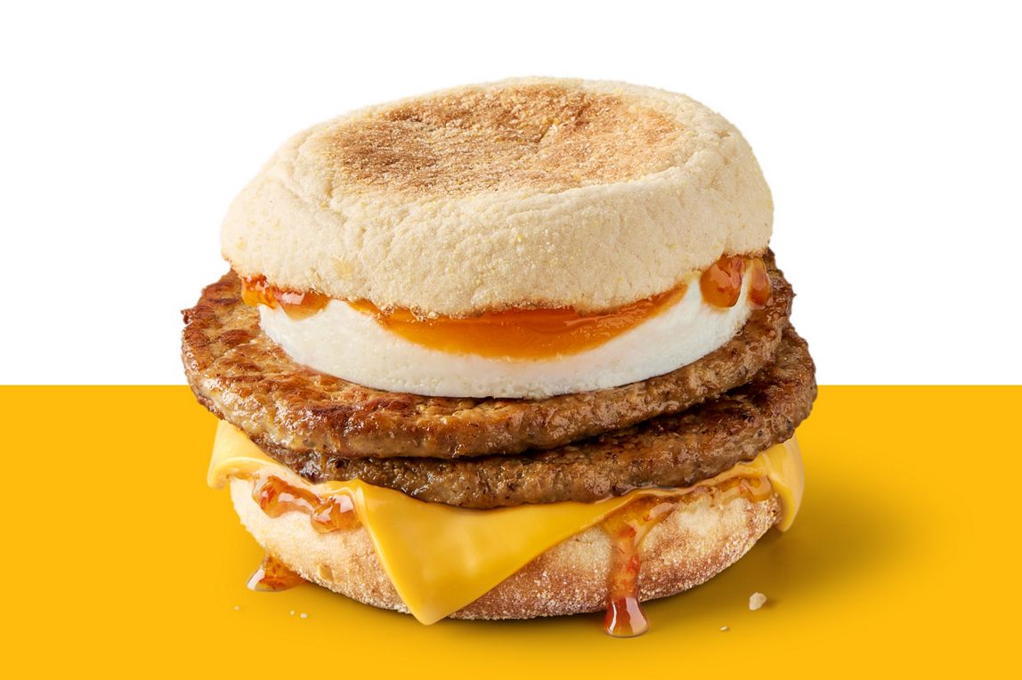 Double sausage and egg McMuffin with cheese and Hot Honey sauce on a toasted English muffin.