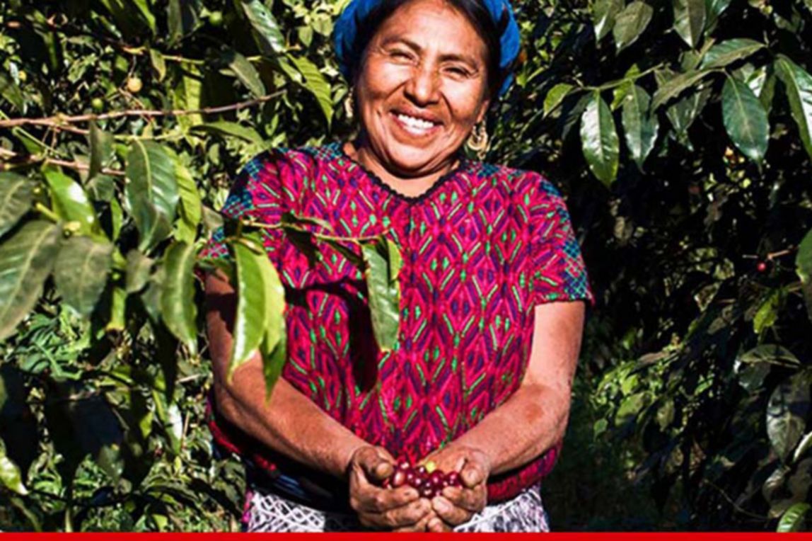 Female farmer smiling around her crops.