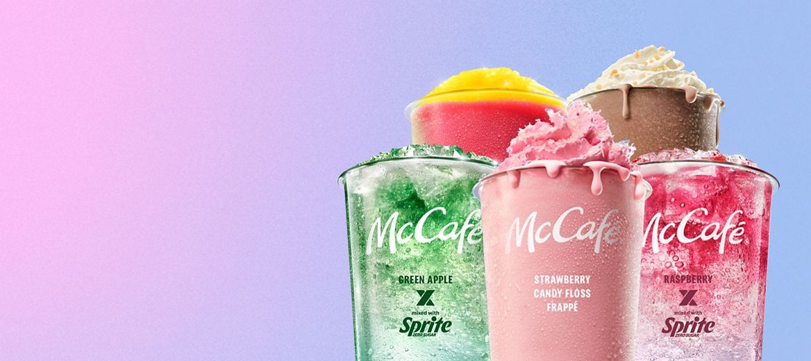 A selection of McCafé cold drinks including a Vanilla Macha Frappe, Chocolate Honeycomb Frappe, Green apple x Sprite Mixology, Raspberry x Sprite Mixology and Caramel Frappe against a peach and yellow background.