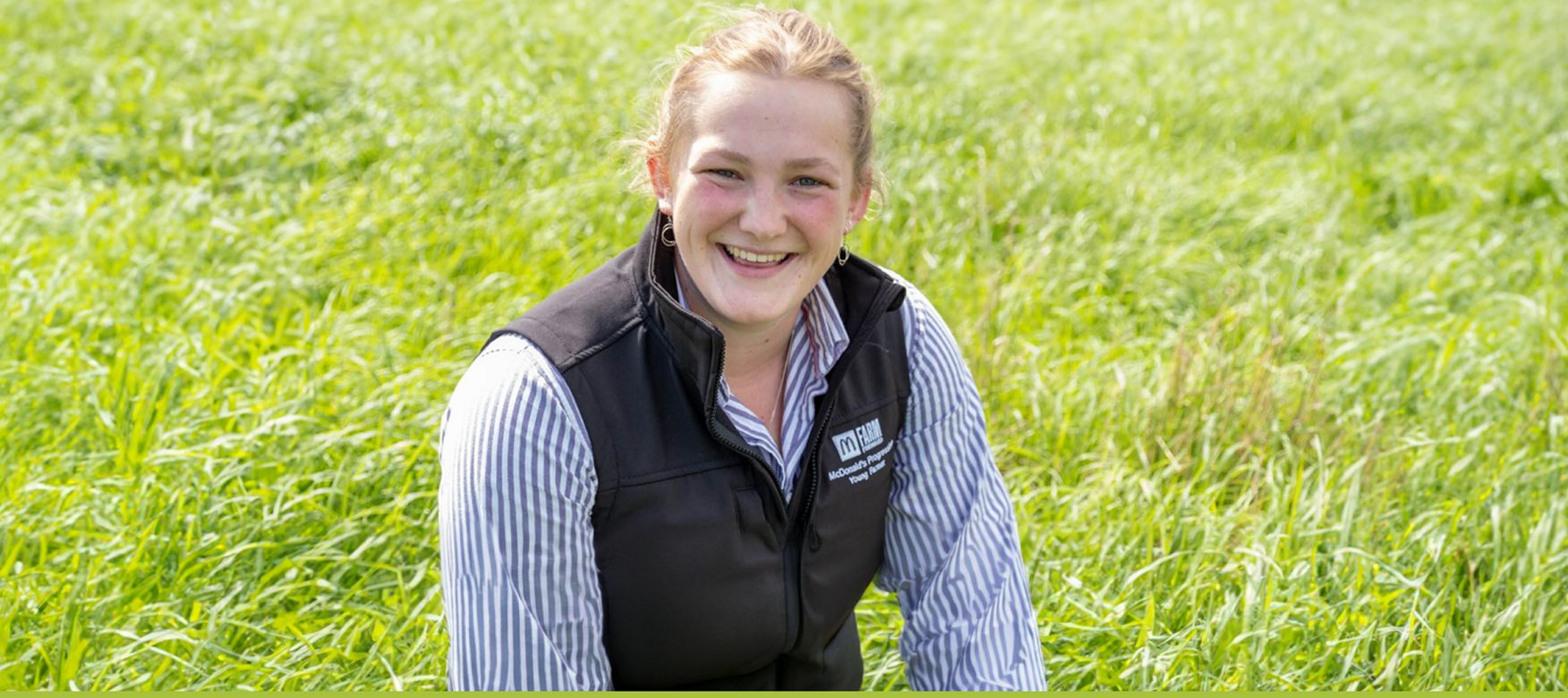 Young female farmer smiles in a field