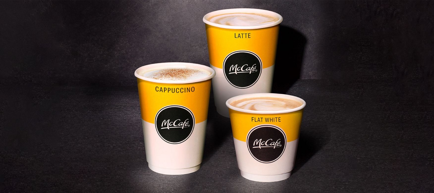  McCafe range of cups standing on a wooden table