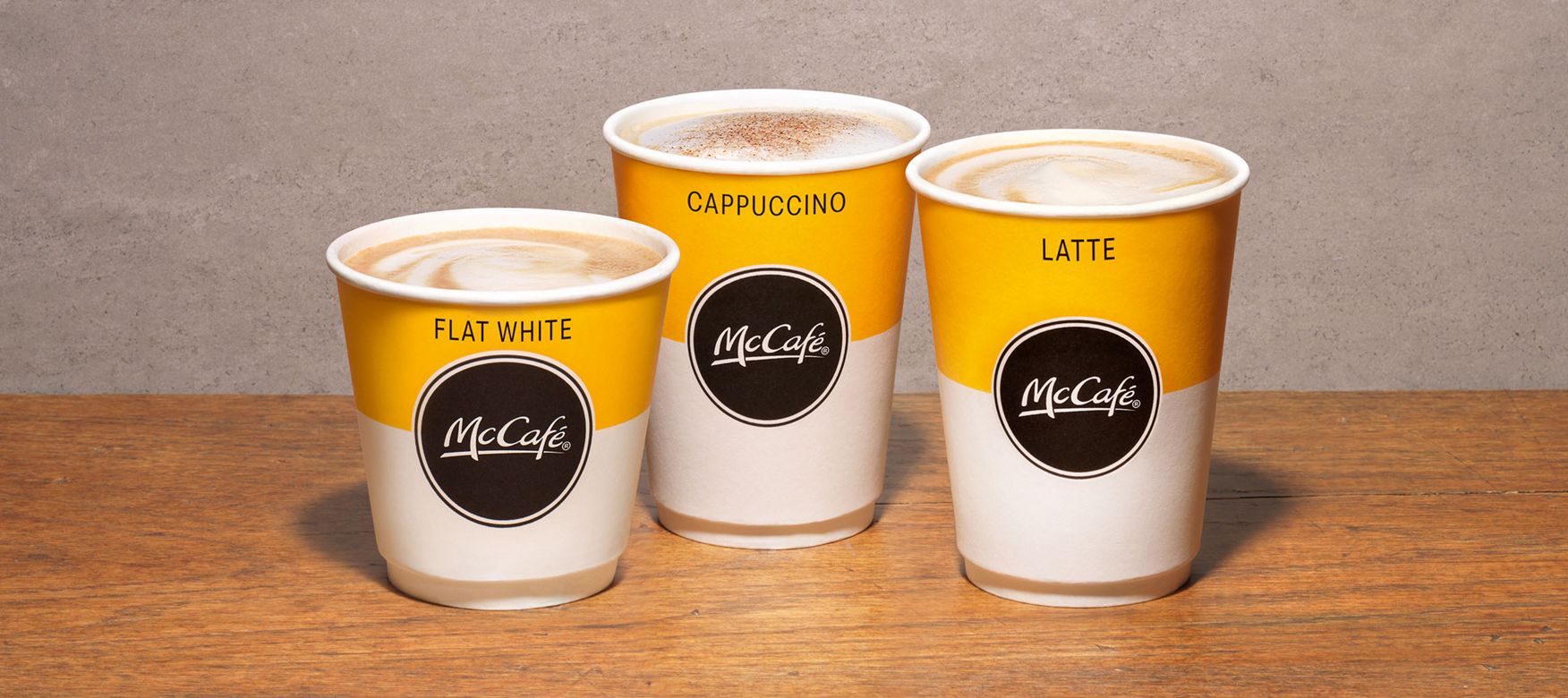  McCafe range of cups standing on a wooden table