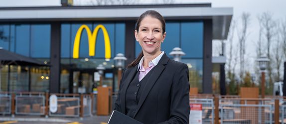 McDonald’s multi-site franchisee smiling outside one of her restaurants.