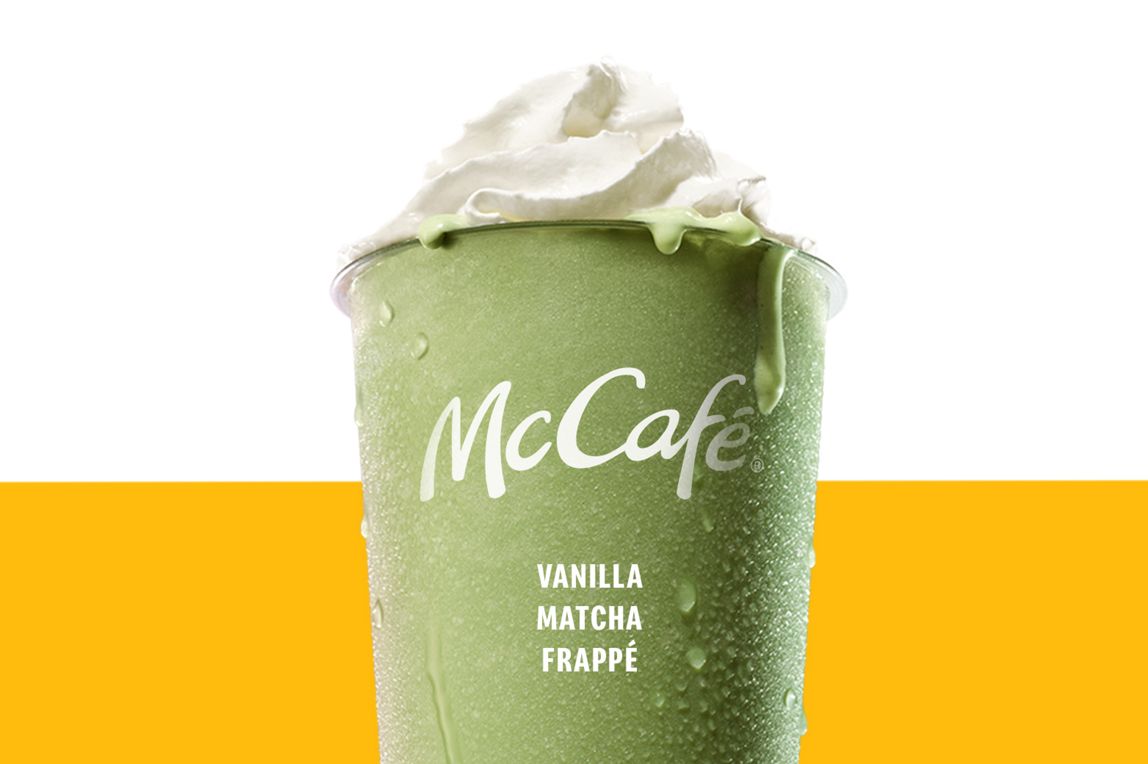 Vanilla Match Frappe in a chilled McCafé cup, topped with whipped cream and against a soft pink and blue background.