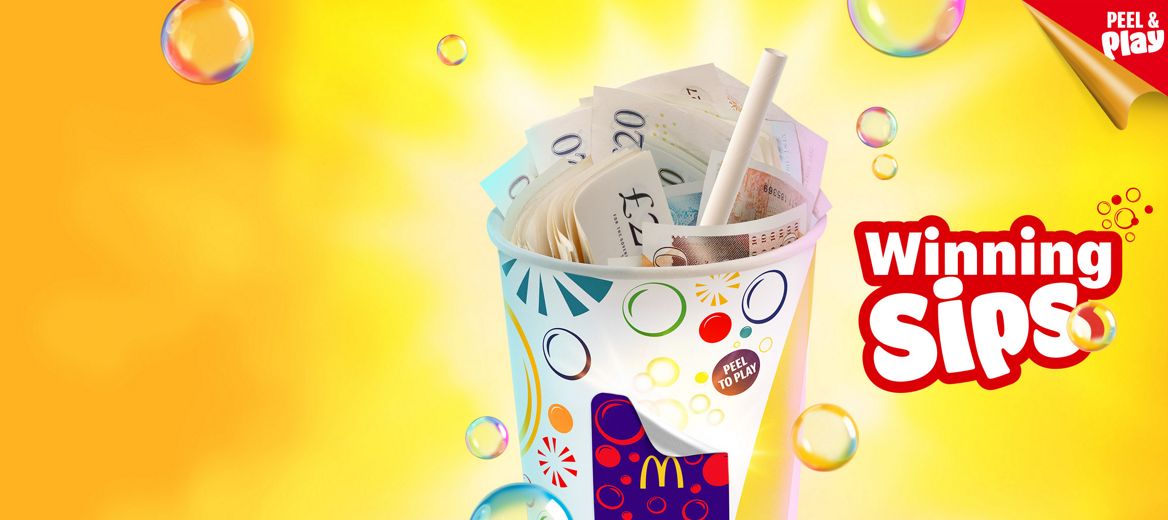 The McDonald’s cup with a peel to win sticker on a yellow background with bubbles.