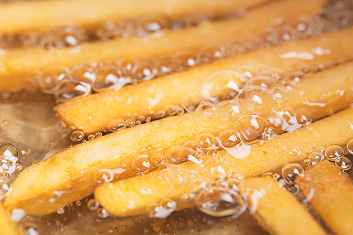 Pommes brutzeln in der Fritteuse