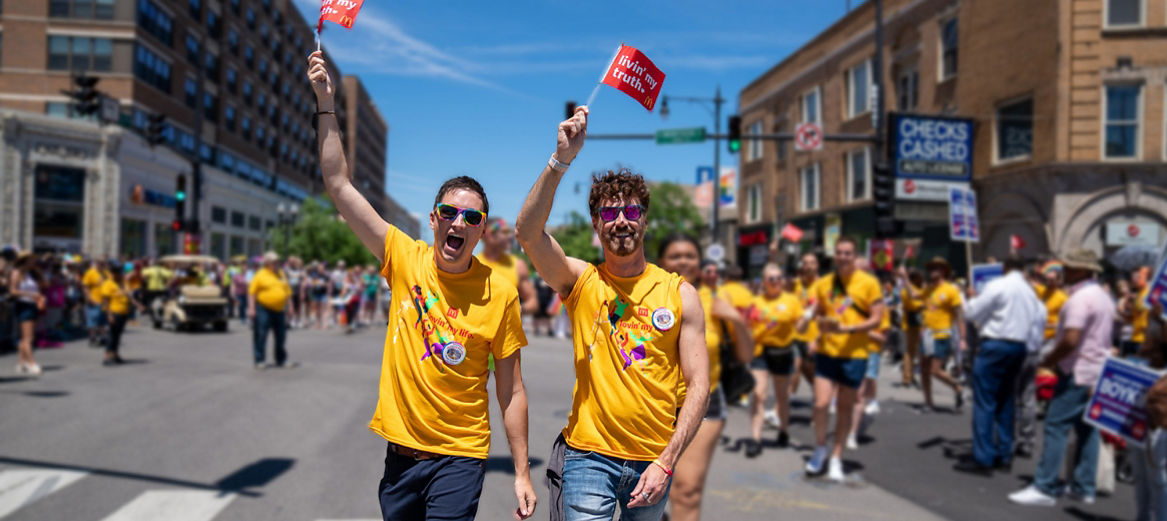 Two people in “lovin’ my life” t-shirts with McDonald’s mini-flags proudly raised in their hands, leading a group of employees down the busy streets of downtown Chicago during the Pride Parade