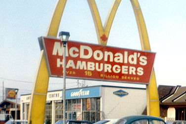 A retro McDonald's signage with arches in front of a McDonald's restaurant