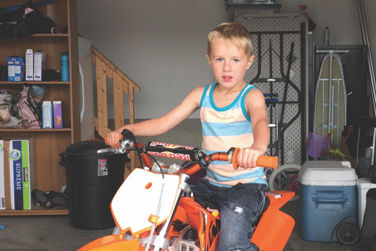 Boy siting on an orange dirt bike