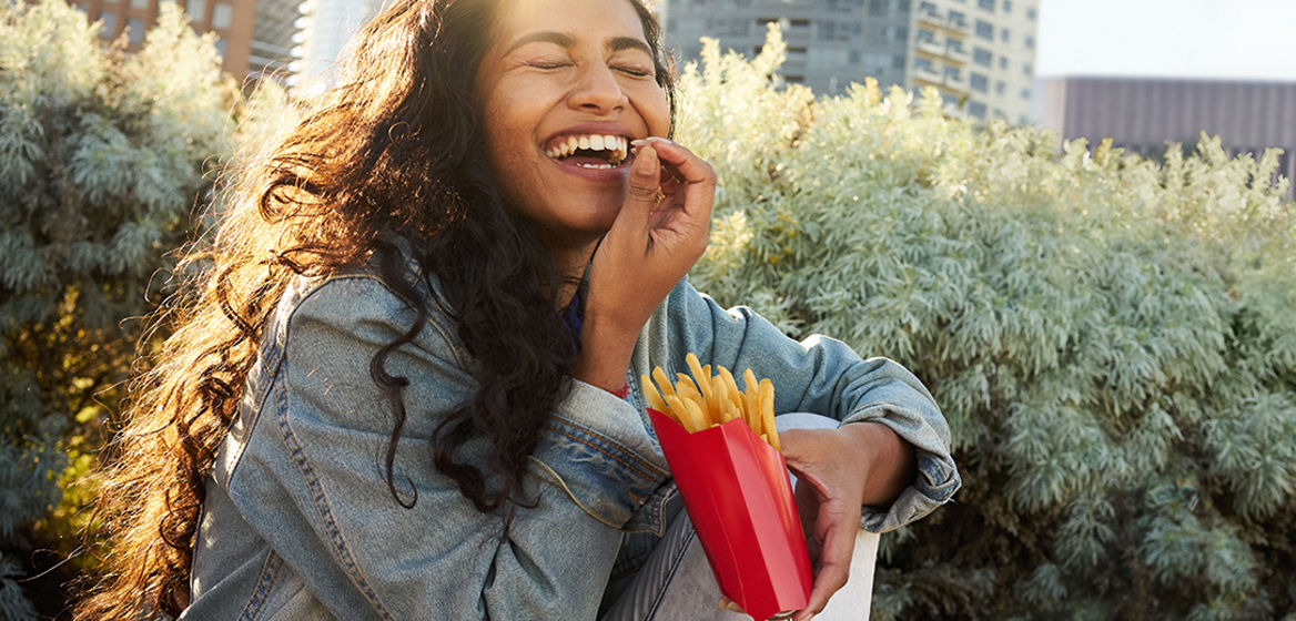 A woman enjoying eating fries