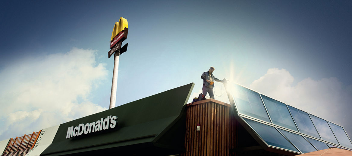 Techniker prüft Solaranlage auf dem Dach eines McDonald's Restaurants