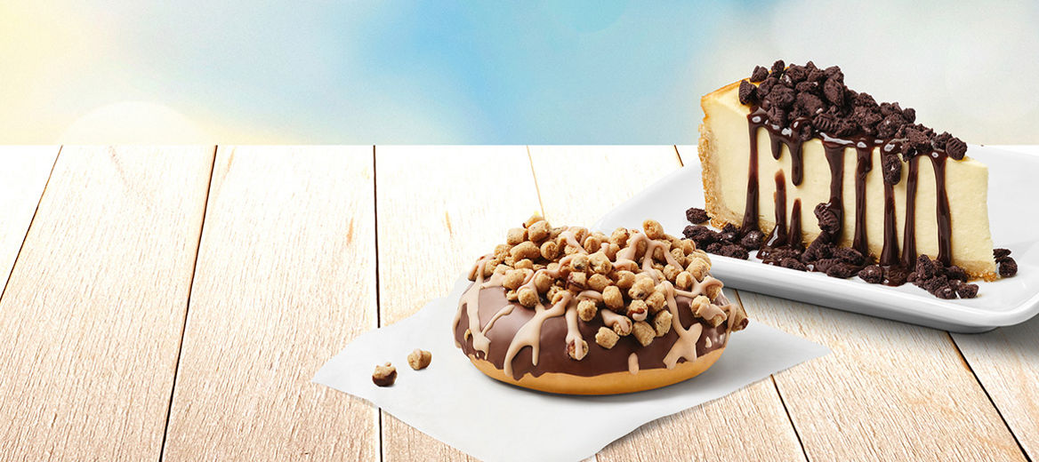 McCafé® Sommerhighlights Cookie Dough Donut mit Keksteigstückchen und McCafé® Kuchen N.Y. Style Cheesecake mit OREO®-Topping und Schoko-Sauce.