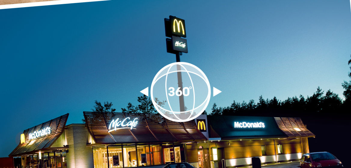 Ein McDonald's Restaurant bei Dämmerung mit einer Illustration in der Mitte, die auf die Möglichkeit eines 360-Grad-Rundgangs verweist