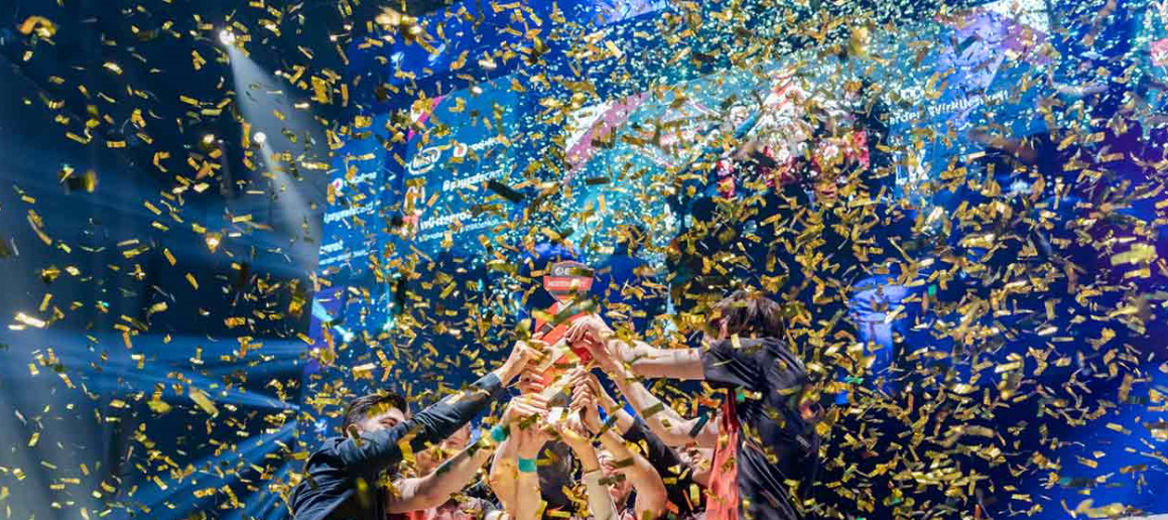E-Sportler stemmen im goldenen Konfettiregen die ESL-Meistertrophäe in die Höhe