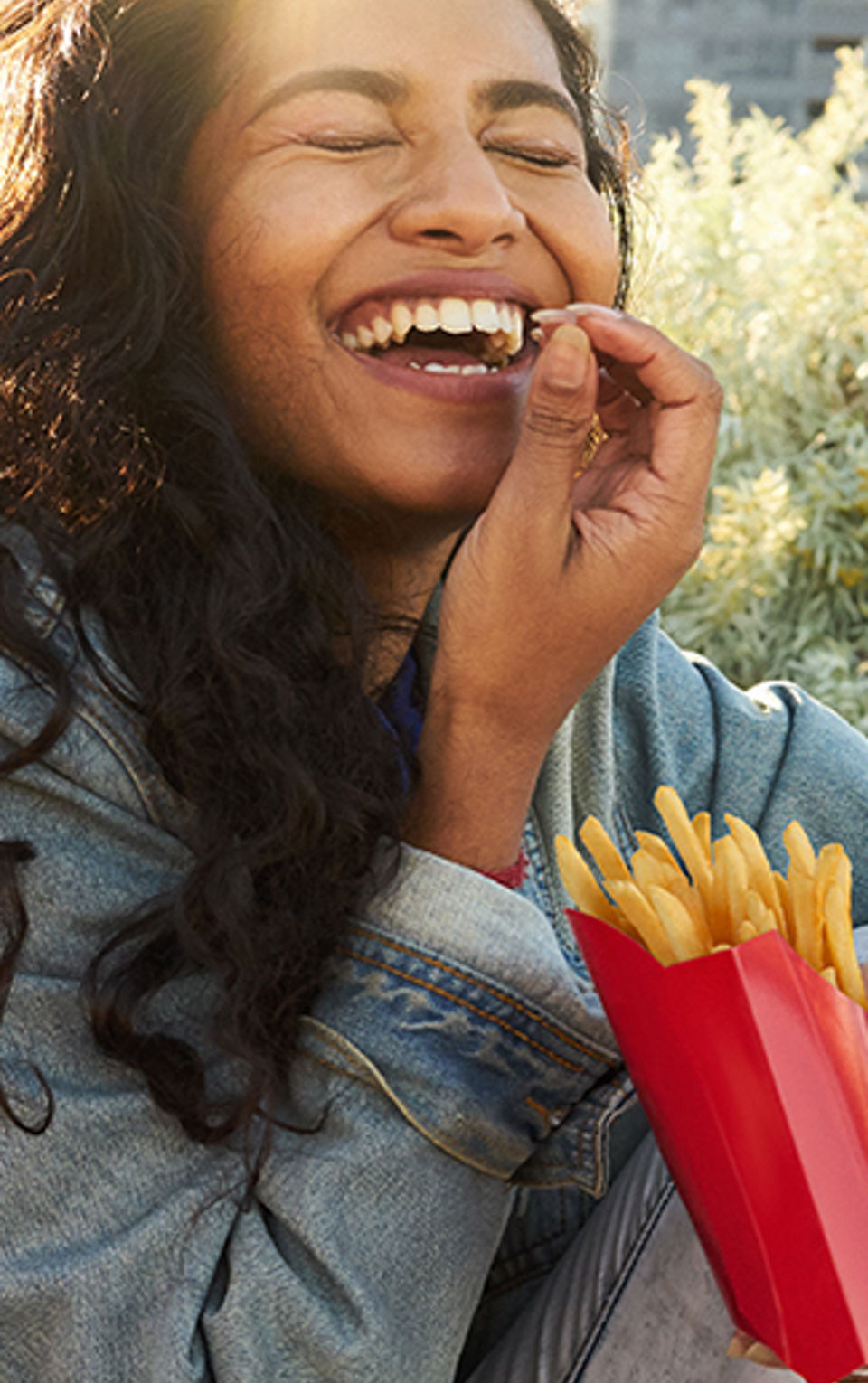A woman enjoying eating fries