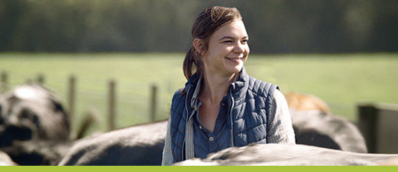 Picture of female farmer with herd of cows.