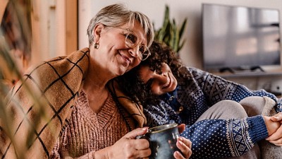 A middle-aged woman leans on her elderly mother