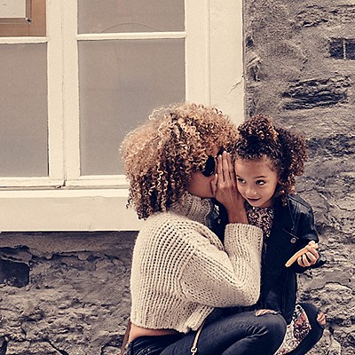 Woman whispering in child's ear