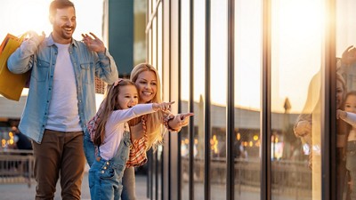 A family window shopping on a sidewalk 