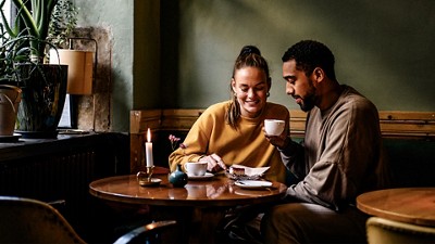 A couple drinking coffee and eating cheesecake