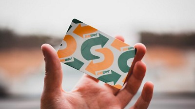 Hand holding a Subway gift card 
