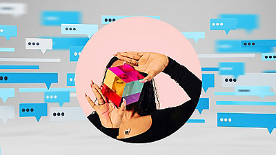 A woman holds a bright, colorful piece of paper, emphasizing its vivid hues and intricate patterns