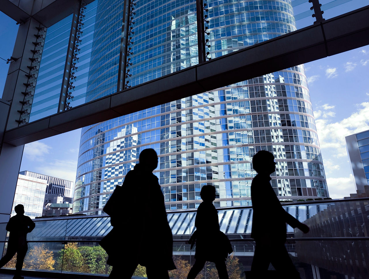 Silhouettes of business people and office workers going to work at Shinagawa business district of Tokyo, Japan.