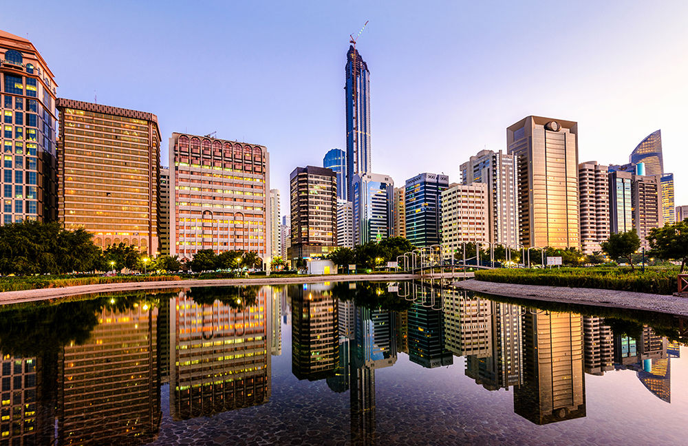 The Abu Dhabi Downtown Skyline and Corniche with the newly developing Central Market Towers at dusk.