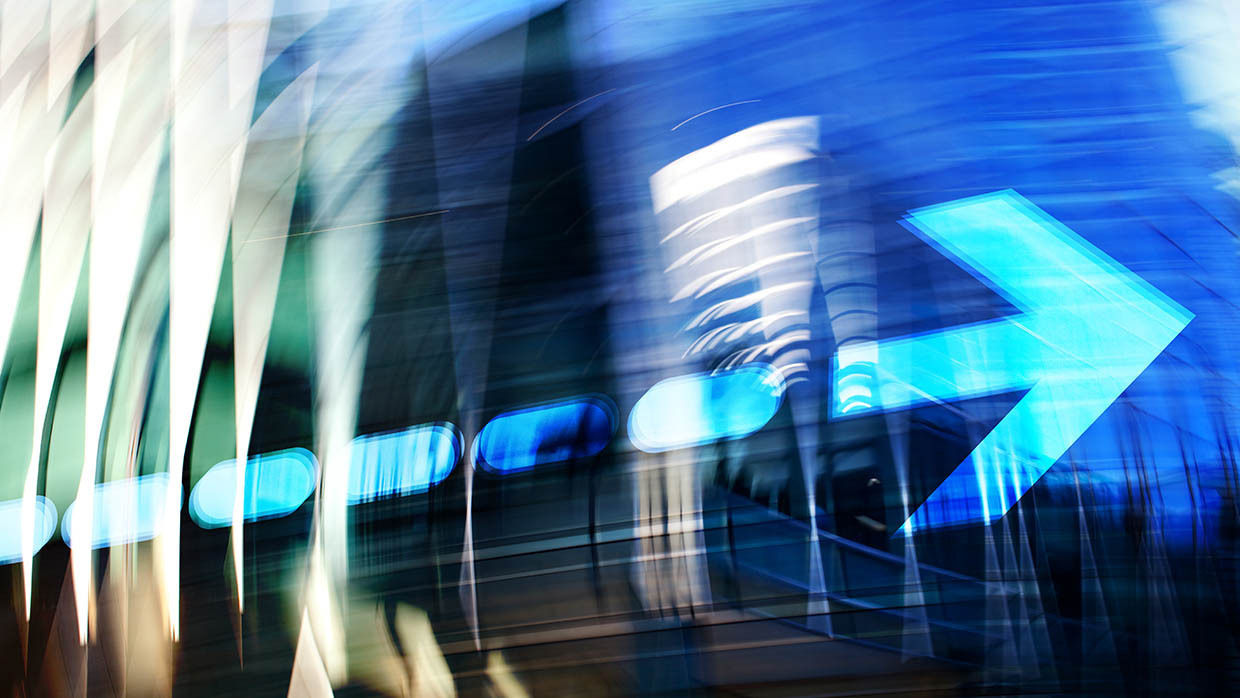 Arrow over blurred Financial District buildings. Digitally generated Image.