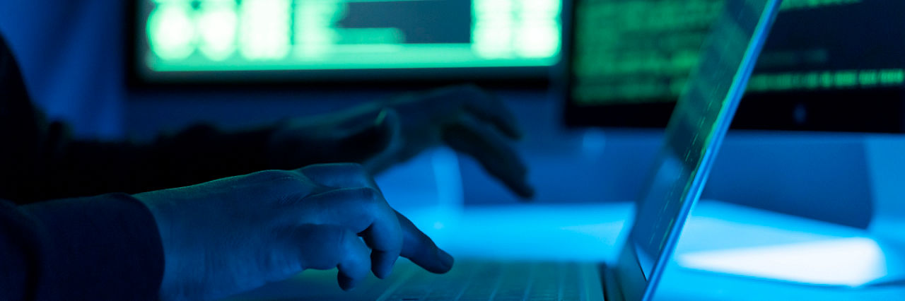 Hacker using laptop. Lots of digits on the computer screen.