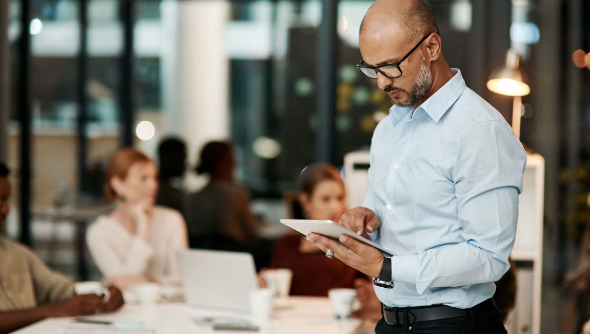 Businessman standing with tablet prepping for meeting
