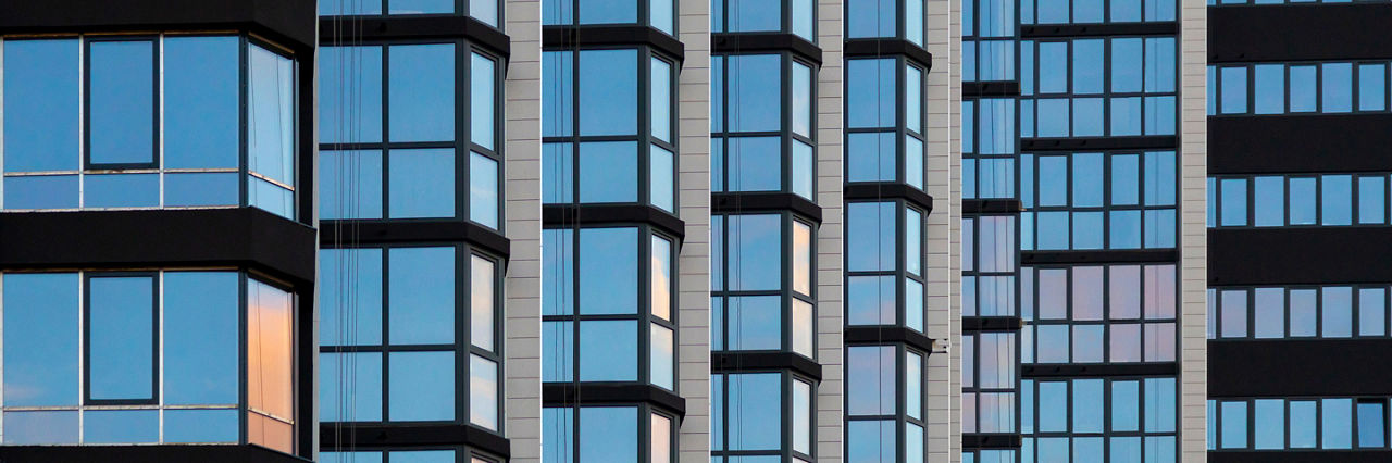 a fragment of the glass facade of a multi-storey building under construction. Architectural and construction background.