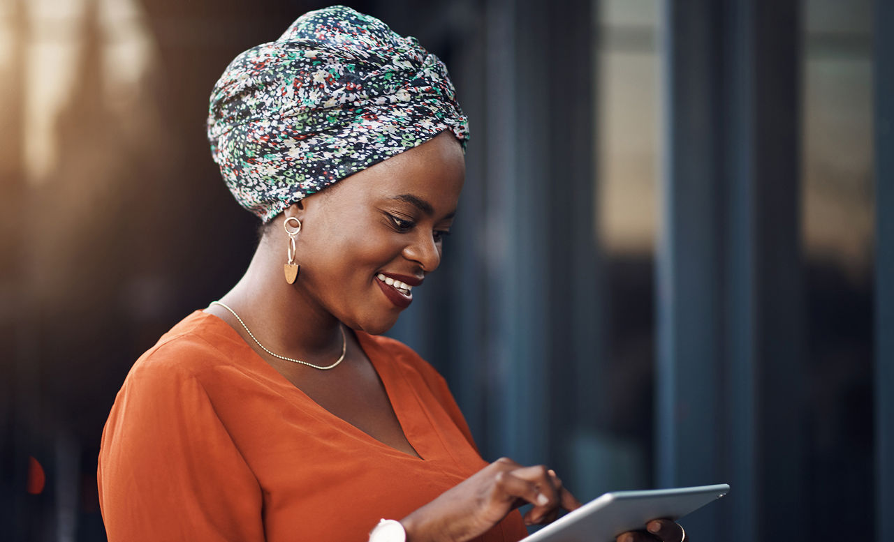 Cropped shot of an attractive businesswoman using her tablet while standing in the office