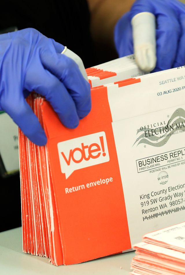 A worker processes mailed-in ballots from Tuesday's primary election, Wednesday, Aug. 5, 2020, at the King County Elections headquarters in Renton, Wash., south of Seattle. Washington state has offered voting by mail since 2011. (AP Photo/Ted S. Warren)