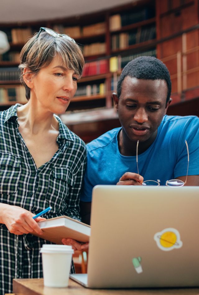 A beautiful middle age woman helping a student with a project