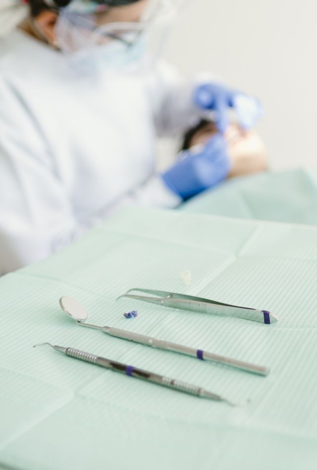 female dentist examining child teeth in dentist's office. Woman dentist with assistant treating patient in a dental office. Close-up of dentist tools.