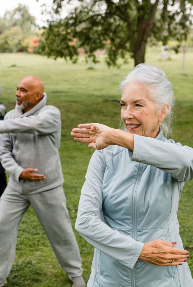 A diverse group of seniors practice martial arts in their local park.