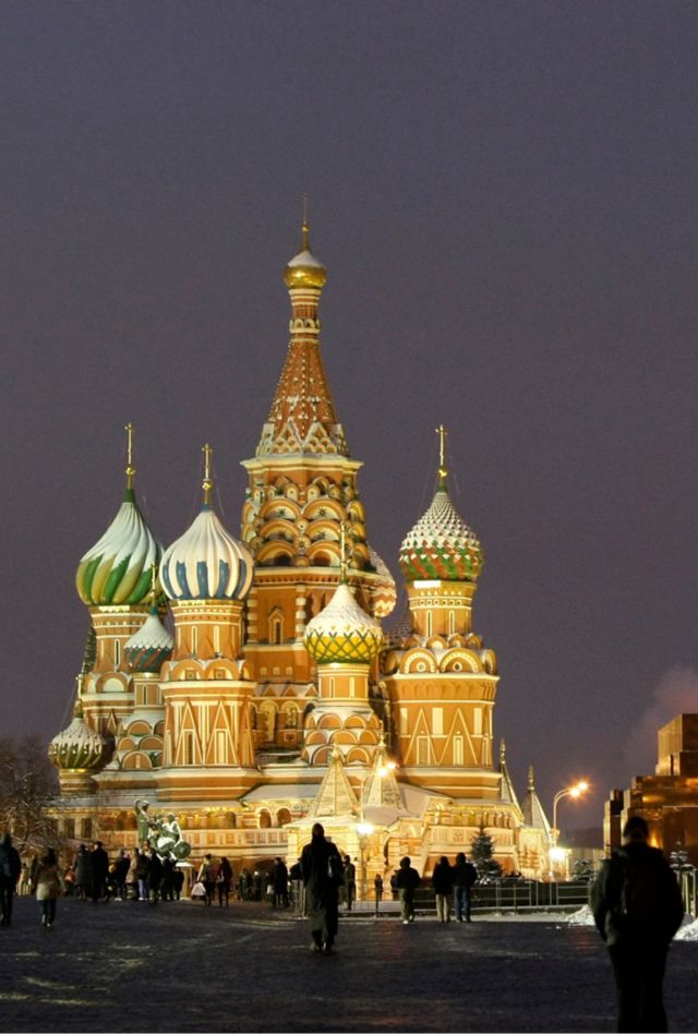 In this Thursday, Dec. 10, 2009 file photo people walk past a huge Christmas tree installed in Red Square, with St. Basil Cathedral,  center, the Kremlin's Spassky Tower, right back, and Lenin Mausoleum, right, in Moscow, Russia. By all accounts, President Vladimir Putin has had a horrible year: Russia’s currency has lost more than half its value, the economy is heading toward recession and he has become a pariah in the West. And yet so far, Putin’s tough, anti-Western rhetoric and aggressive actions in neighboring Ukraine have helped him weather the storm, with a new Associated Press-NORC Center poll showing that 81 percent of Russians still support their president. (AP Photo/Misha Japaridze, File)