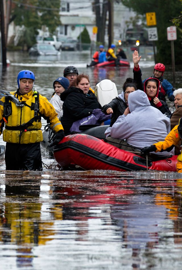 People, some waving to those on dry ground, are rescued by boat in Little Ferry, N.J. Tuesday, Oct. 30, 2012 in the wake of superstorm Sandy. The storm, which made landfall Monday evening, caused multiple fatalities, halted mass transit and cut power to more than 6 million homes and businesses. (AP Photo/Craig Ruttle)