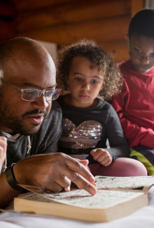 An adult reads to a group of children