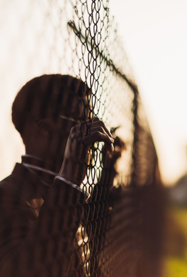 African man behind an iron grid