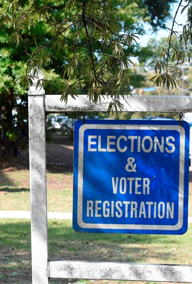 Voters wait in line outside the Richland County election office on the first day of in-person absentee voting in South Carolina on Monday, Oct. 5, 2020, in Columbia, S.C. A number of counties have polling places where people can vote almost like they would in person on Election Day, instead of having to mail in their absentee ballot. (AP Photo/Meg Kinnard)